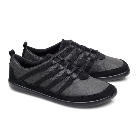 Die SPARQ Low Pinatex Black Sneaker von ZAQQ bestechen durch ihr elegantes Design mit strukturierter Oberfläche, schwarzen Schnürsenkeln und einer flachen Sohle. Sie sind aus Pinatex-Material gefertigt, das für ein minimalistisches und modernes Aussehen sorgt, und verfügen außerdem über rutschhemmenden Kautschuk für besseren Halt.