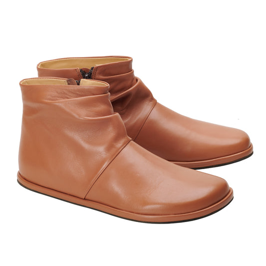 Die QOURTNEY Brown Stiefeletten von ZAQQ werden nebeneinander auf einem weißen Hintergrund angezeigt. Diese braunen Lederstiefel aus Nappaleder mit flacher Sohle und praktischen seitlichen Reißverschlüssen zeichnen sich durch ein minimalistisches Design mit einer leicht faltigen Textur auf der Oberseite für zusätzlichen Charakter aus.