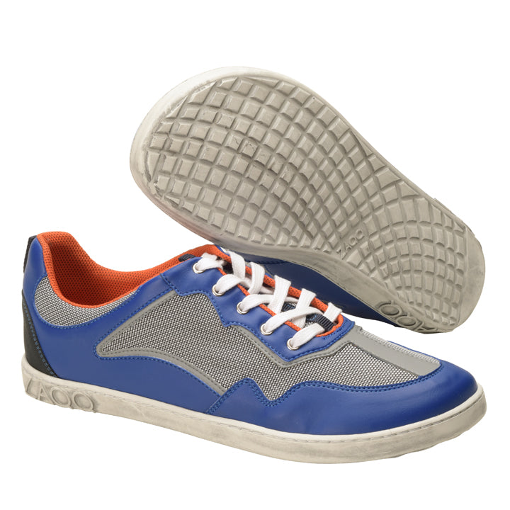 Die QOPA Blue Sneaker von ZAQQ zeichnen sich durch ein atmungsaktives blau-graues Mesh-Design, ein orangefarbenes Futter und weiße Schnürsenkel aus. Ein Schuh wird aufrecht und der andere auf der Seite präsentiert und hebt eine strukturierte Sohle hervor.