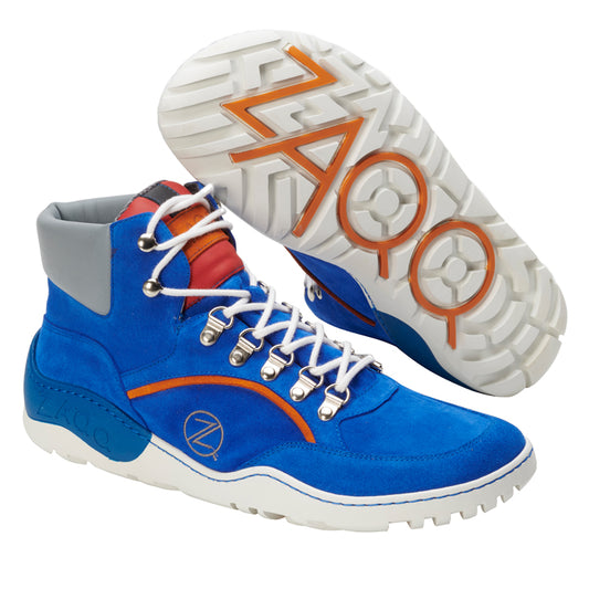 Wir präsentieren den TERRAQ Azure Waterproof von ZAQQ: Ein Paar leuchtend blaue High-Top-Sneaker mit weißer Sohle und Schnürung, hervorgehoben durch orangefarbene und rote Akzente aus Veloursleder. Die Laufsohle verfügt über ein einzigartiges geometrisches Muster und ein Z-Design für hervorragende Traktion, was sie zum perfekten Outdoorschuh macht.