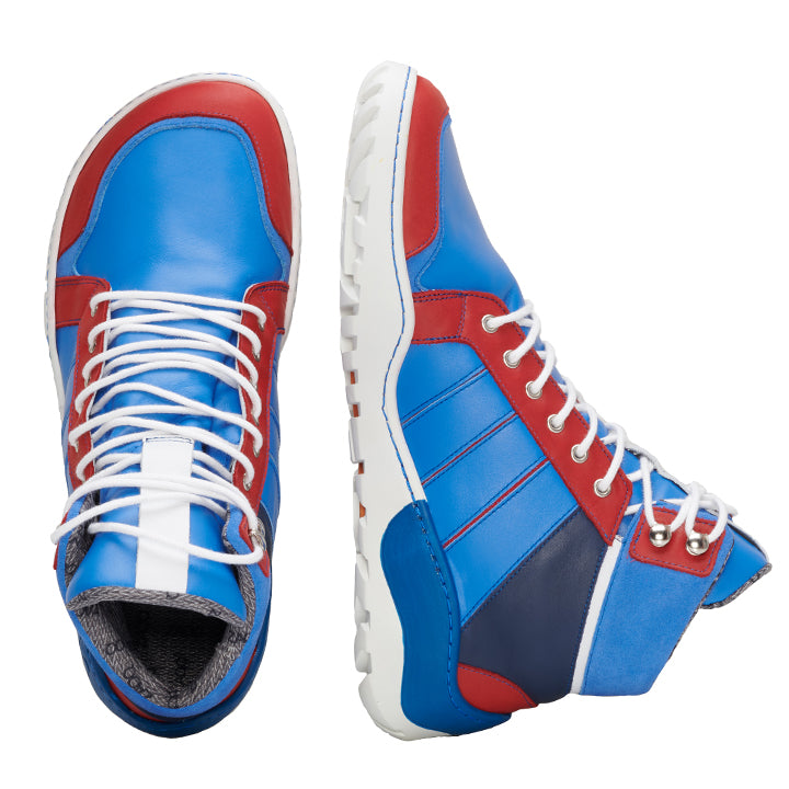 Ein Paar High-Top-Sneakers mit lebendigem Design in Blau, Rot und Weiß. Ähnlich wie der MONTBLANQ Blue Waterproof-Stil von ZAQQ verfügen diese Schuhe über weiße Schnürsenkel und eine strukturierte ZAQQ TERRA Sohle auf weißem Hintergrund.