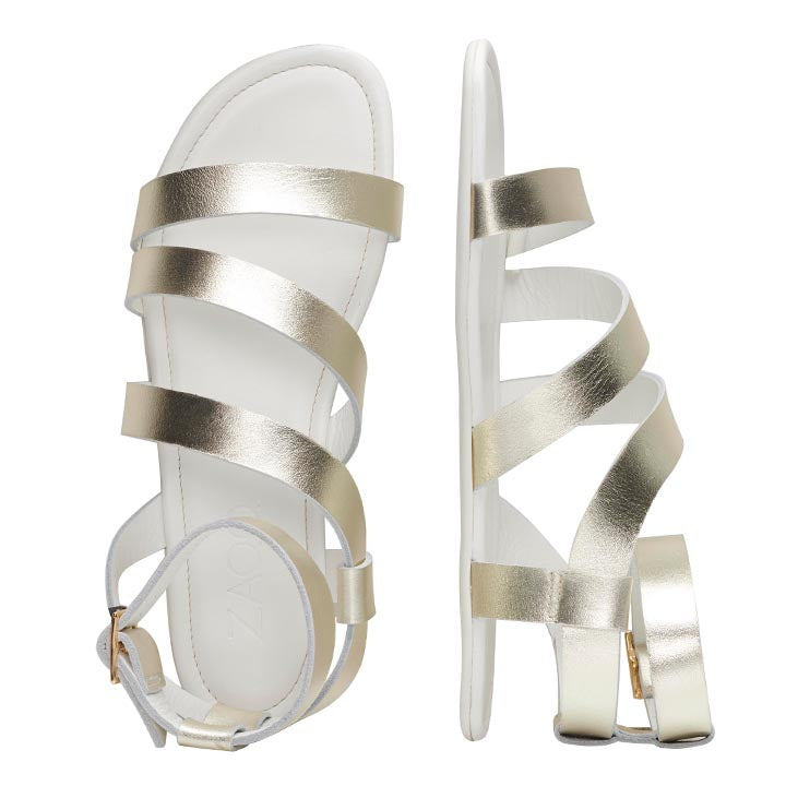 Wir präsentieren die eleganten MONIQ Champagne-Sandalen von ZAQQ in einem eleganten Glattleder-Design in Metallic-Gold mit einem raffinierten Schnallenverschluss. Eine Sandale ist von oben und die andere von der Seite zu sehen, wodurch mehrere Riemen hervorgehoben werden, die den Fuß schmücken und den Knöchel umschließen – eine ideale Wahl für schicke Sommeroutfits.