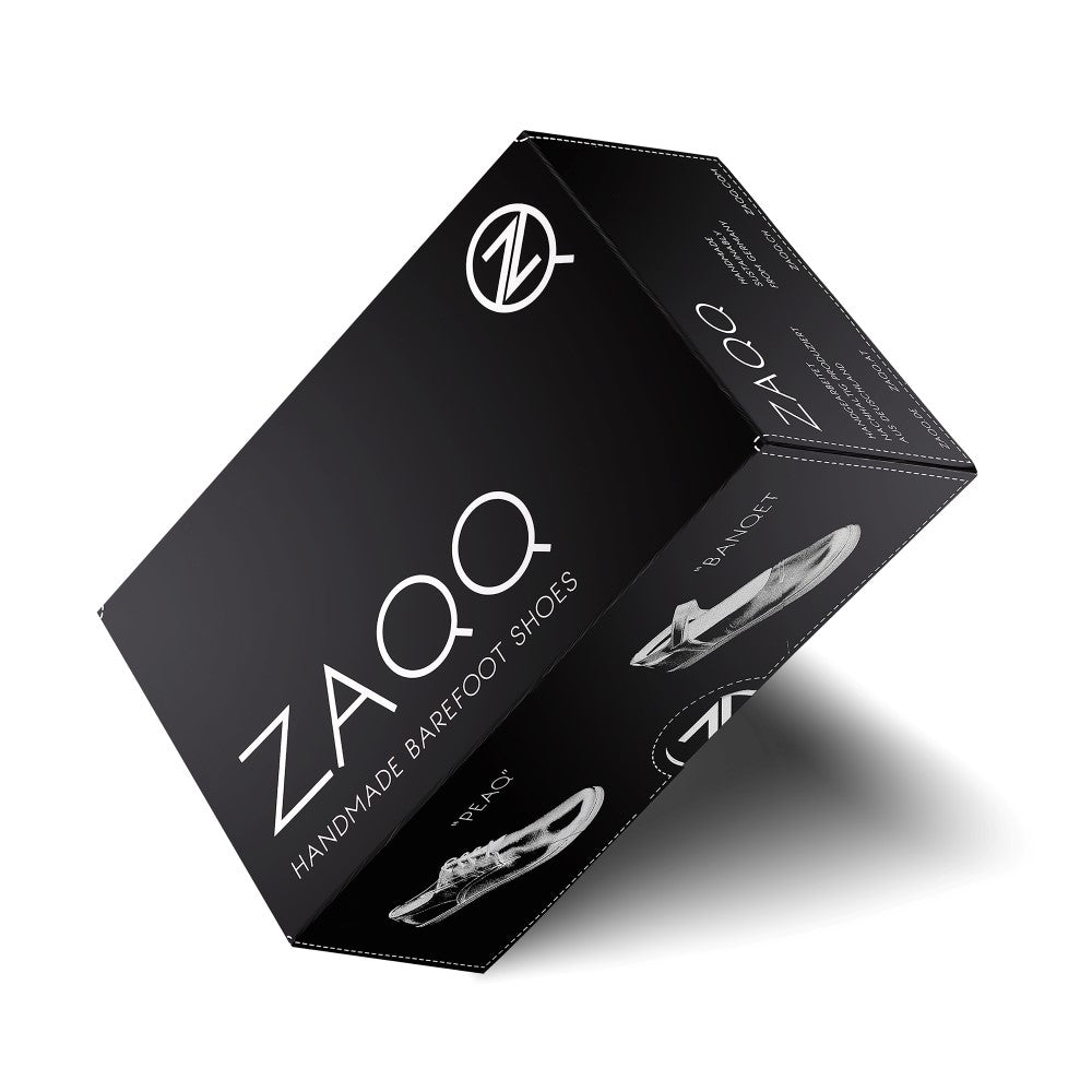 Ein schwarzer Schuhkarton mit der Aufschrift „QQQ Low Black White“ von ZAQQ, mit minimalistischem Logo und Design. Der Karton ist schräg gestellt und zeigt die Marke sowie ein Graustufenbild eines Sneakers auf der Seite, um den Tragekomfort hervorzuheben.