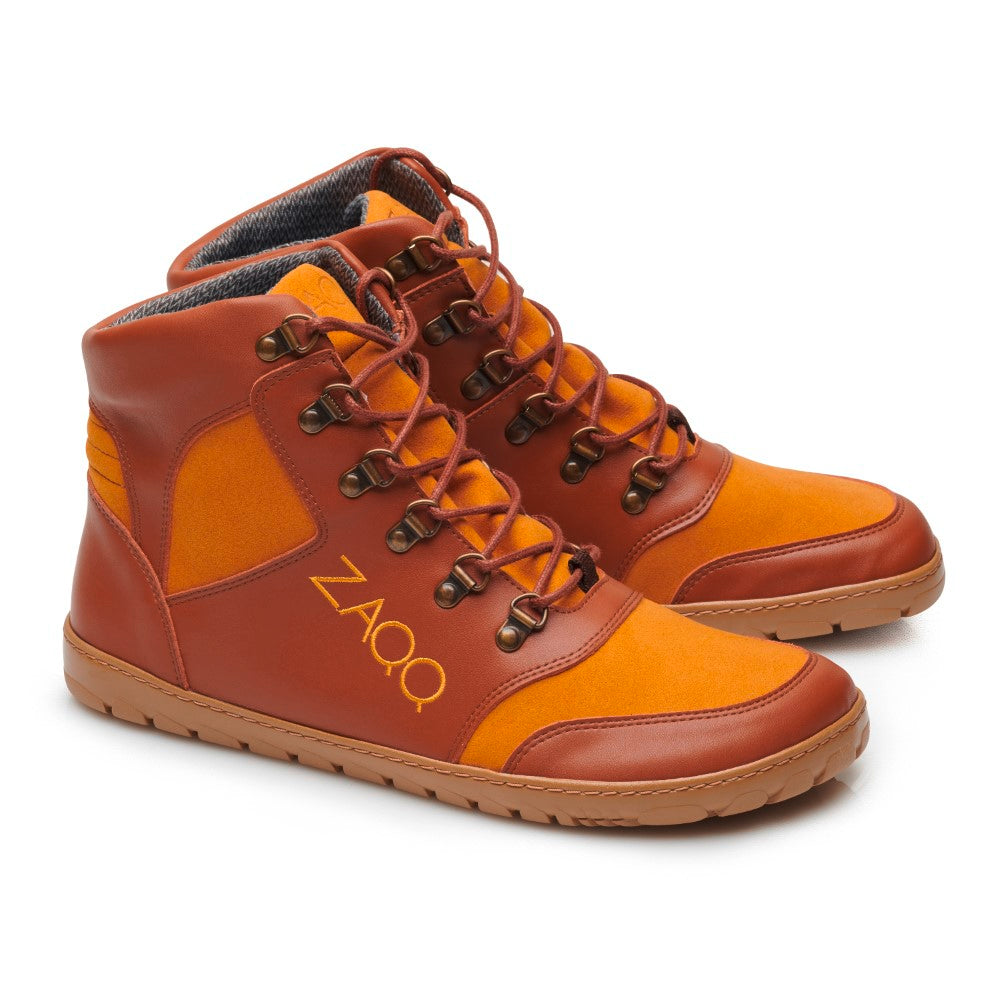 Wir präsentieren den HIQE Vegan Sierra Waterproof von ZAQQ: ein Paar orange-braune High-Top-Sneaker mit dicken Schnürsenkeln, einem auffälligen Logo an der Seite, einer strukturierten Sohle und einem weichen Innenfutter für Komfort und Stil. Diese umweltfreundlichen Schuhe werden als veganer Wanderschuh hergestellt, um nachhaltige Abenteuer zu gewährleisten.