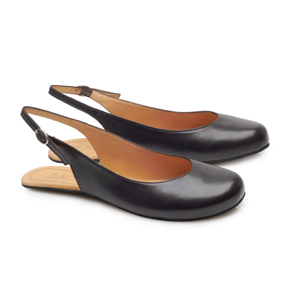 Die PINQ Black von ZAQQ sind ein Paar schwarze Slingback-Schuhe mit mandelförmiger Spitze und verstellbaren Knöchelriemen. Diese Schuhe im Ballerina-Stil haben einen niedrigen Absatz und eine hellbraune Innensohle und bieten so eine perfekte Balance zwischen Komfort und Eleganz. Das Design ist schlicht und doch raffiniert, was sie ideal für sowohl legere als auch formelle Anlässe macht.