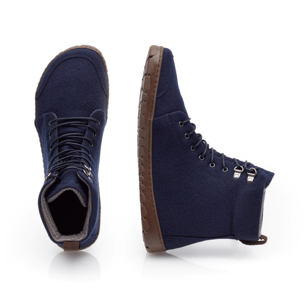 Wir präsentieren den QICE Blue von ZAQQ, ein Paar dunkelblaue High-Top-Schuhe für jedes Abenteuer. Diese Schuhe mit brauner Outdoorsohle aus Gummi bieten eine aufrechte Seitenansicht und eine Draufsicht. Sie sind mit silbernen Ösen und Schnürsenkeln vorne für zusätzlichen Stil ausgestattet.