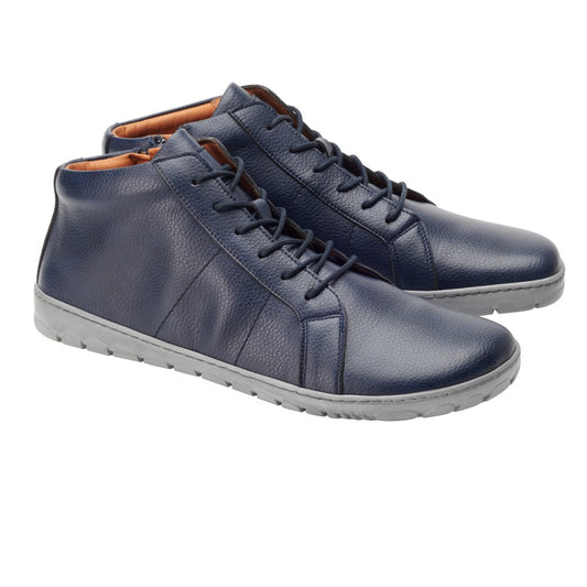 Die QORE Mid Vegan Navy High-Top-Sneaker von ZAQQ haben einen komfortableren Schnitt mit grauen Sohlen. Diese marineblauen Schuhe haben Schnürsenkel und ein strukturiertes Aussehen auf weißem Hintergrund.