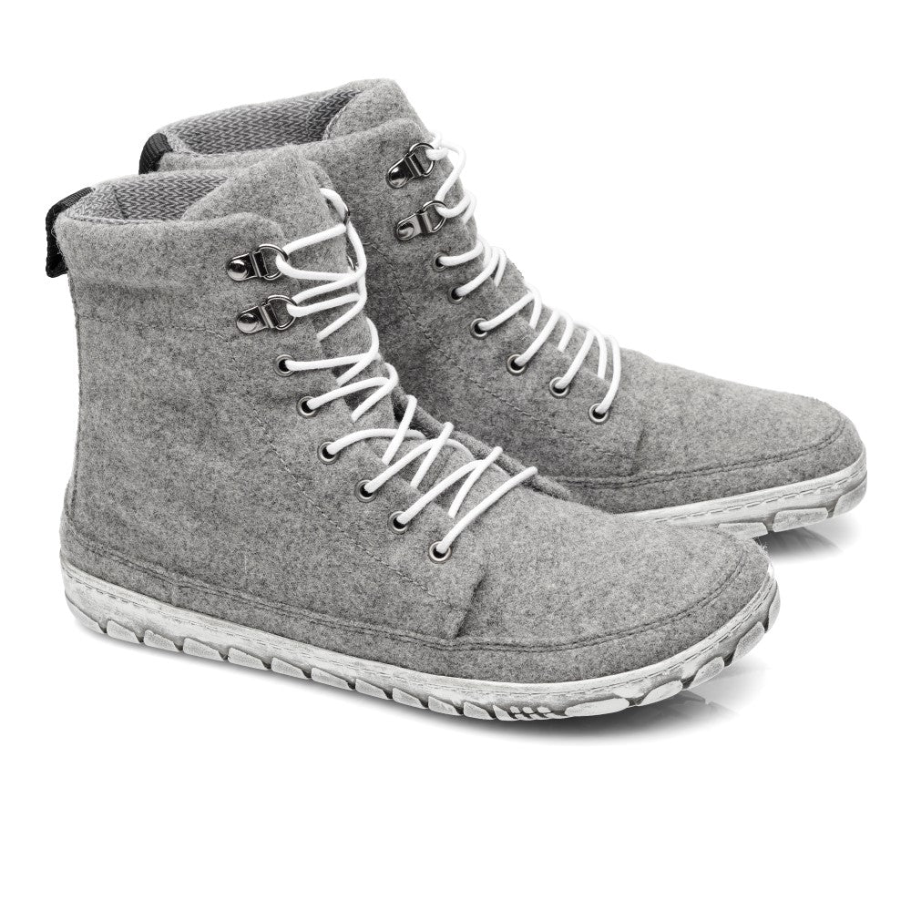 Wir präsentieren den QICE Grey von ZAQQ: ein stylisches Paar High-Top-Filz-Sneaker in Grau mit weißen Schnürsenkeln und robusten weißen Gummisohlen. Diese Sneaker verfügen über eine Outdoorsohle für besseren Halt, komplett mit Metallösen und einem strukturierten Muster auf der Außensohle, was sie ideal für jedes Abenteuer macht.