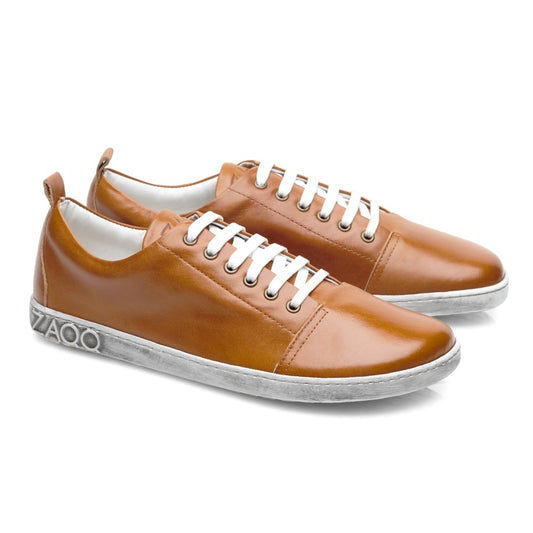 Der TAQQ Nappa Brown von ZAQQ ist ein Paar brauner Barfuß-Sneaker, die sich durch ihr klares und schlichtes Design auszeichnen. Mit weißen Schnürsenkeln, Sohlen und einem Markenlogo auf der Rückseite der Ferse kombinieren diese Schuhe dank ihrer flexiblen Barfußsohle Stil mit Komfort.